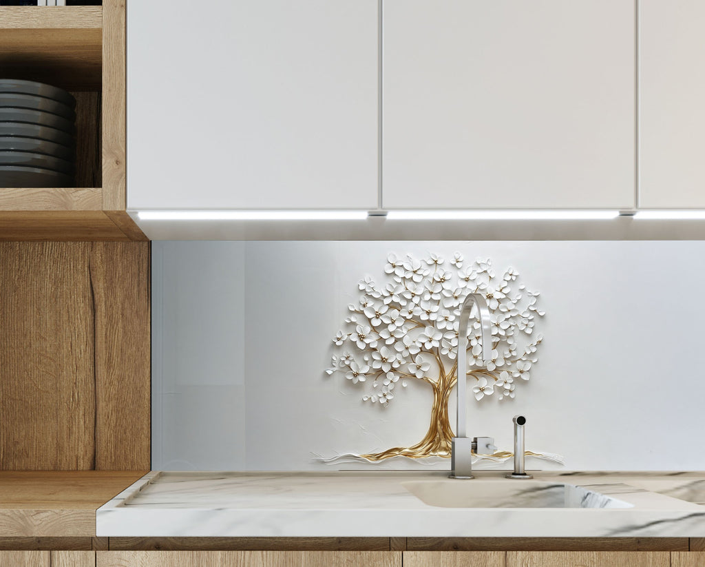 Pure white glass backsplash with delicate floral tree design and golden trunk.

