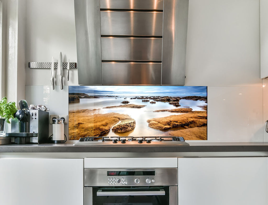a flat screen tv mounted on a wall above a stove